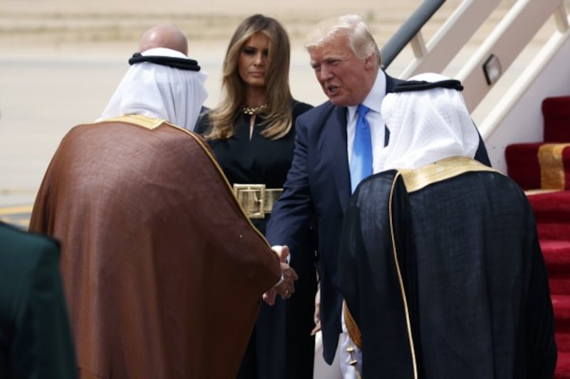 U.S. President Donald Trump, top right, accompanied by first lady Melania Trump, center, shake hands