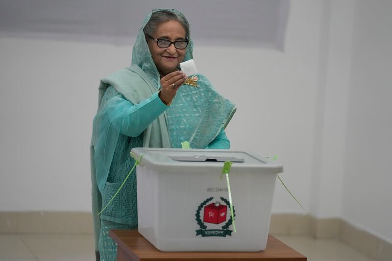 Ms Hasina shows her ballot paper as she casts her vote in Dhaka, Bangladesh (Altaf Qadri, AP)