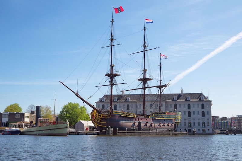 A replica of a historic three-masted clipper moored in front of the National Maritime Museum in Amsterdam