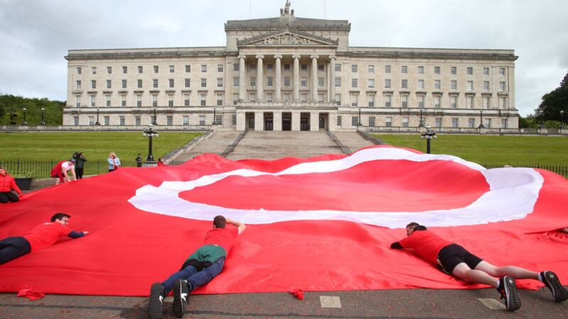 An Dream Dearg at Stormont unfurled a 70ft flag with a symbol representing the campaign for Irish language rights as legislation was introduced in the House of Lords in May 2022. Picture by Mal McCann&nbsp;