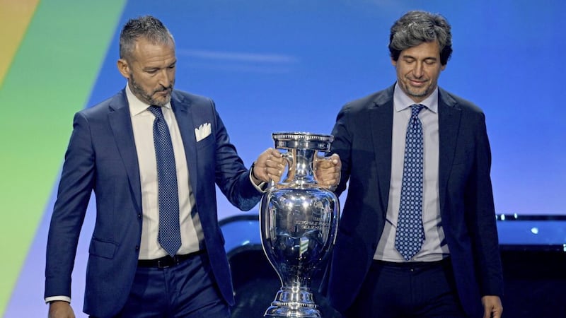 Former Italy stars Gianluca Zambrotta (left) and Demetrio Albertini bring the trophy onto the stage at Sunday&#39;s draw for Euro 2024 qualifying in Frankfurt, Germany Picture by AP 