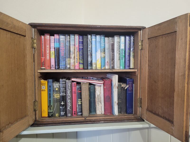 Image of small brown square book case with old books in it