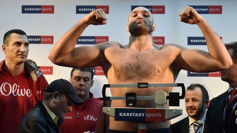 Tyson Fury is weighed while Wladimir Klitschko looks on ahead of Saturday's title clash in Duesseldorf's LTU arena<br />Picture by PA