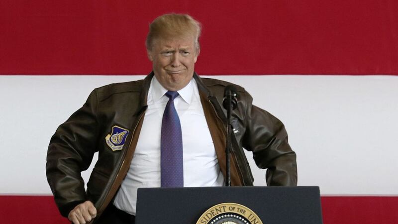 President Trump puts on a military jacket as he meets the US troops at the US Yokota Air Base, on the outskirts of Tokyo, Sunday PICTURE: Eugene Hoshiko/AP 