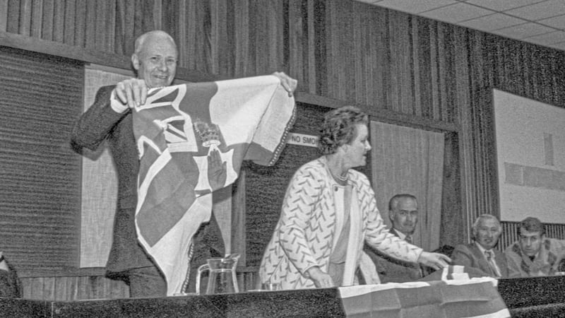 Councillors Tommy Poole and Ethel Smyth unveil flags in Down Council chamber in 1985. Picture by Bobbie Hanvey, courtesy of JJ Burns Library, Boston College. 