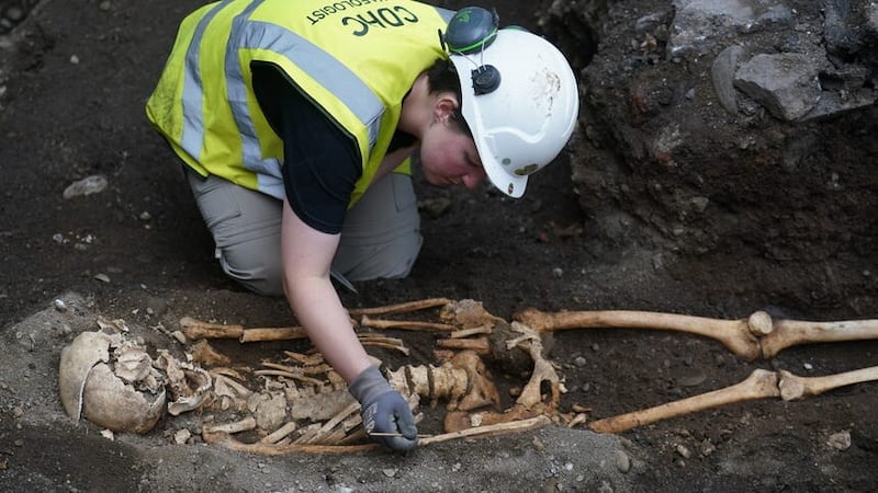 A member of the archaeology team works on a skeleton at an ancient burial site on the new Bullitt Hotel development site (Brian Lawless/PA)