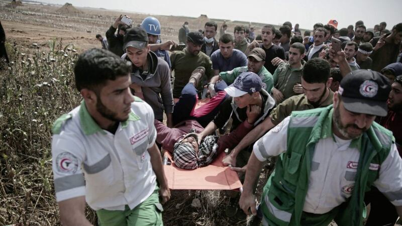 Palestinian medics evacuate a wounded man who was shot by the Israeli troops during a protest at the Gaza Strip&#39;s border with Israel, on Friday. Picture by Khalil Hamra, Associated Press 