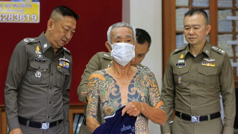 Japanese gang member Shigeharu Shirai displays his tattoos at a police station during a press conference in Lopburi, central Thailand PICTURE: AP 
