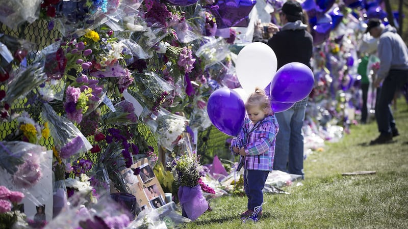 One-year-old Mary Sereg, from Minneapolis, holds balloons as she looks at the memorial set up on a gate outside Prince's house at Paisley Park. Picture by&nbsp;Renee Jones Schneider, Star Tribune via Associated Press<br />&nbsp;