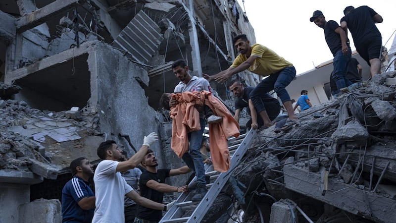 Palestinians rescue a young girl from the rubble of a destroyed residential building following an Israeli airstrike. Picture by AP Photo/Fatima Shbair