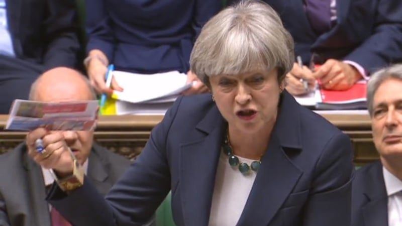Theresa May holds up a Labour Party leaflet as she speaks during Prime Minister's Questions in the House of Commons, London&nbsp;